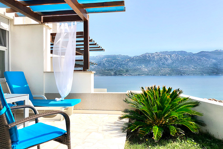Private Terrasse mit Liegestühlen und Pergola, Blick über die Bucht